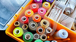 Storage box with spools of multi-colored threads, sewing needles. Storage system for sewing needlework at home