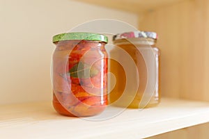 Storage cabinet in kitchen, storage with wooden shelves with food. Shelves of homemade canned vegetables preserves