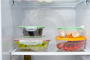 Storage containers with fresh food in a fridge