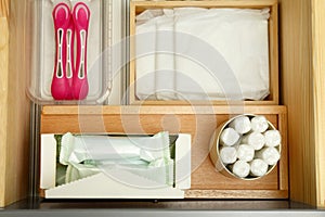 Storage of different feminine hygiene products in wooden drawer, top view