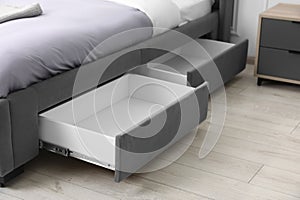 Storage drawers for bedding under modern bed in room