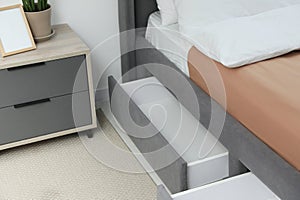 Storage drawers for bedding under modern bed in room