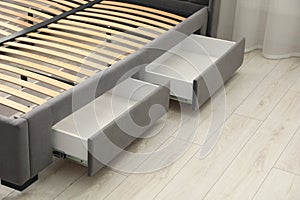 Storage drawers for bedding under modern bed in room