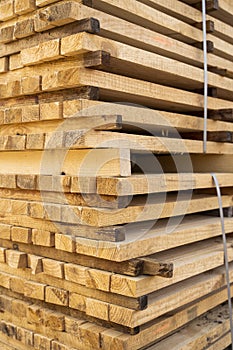 Storage of piles of wooden boards on the sawmill. Boards are stacked in a carpentry shop. Sawing drying and marketing of