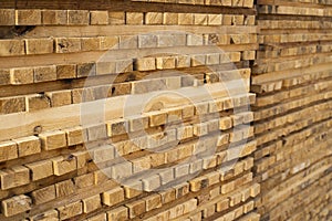 Storage of piles of wooden boards on the sawmill. Boards are stacked in a carpentry shop. Sawing drying and marketing of