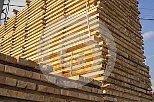 Storage of piles of wooden boards on the sawmill. Boards are stacked in a carpentry shop. Sawing drying and marketing of