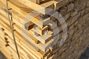 Storage of piles of wooden boards on the sawmill. Boards are stacked in a carpentry shop. Sawing drying and marketing of