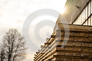 Storage of piles of wooden boards on the sawmill. Boards are stacked in a carpentry shop. Sawing drying and marketing of