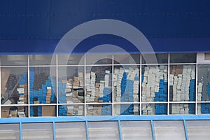 The storage room is full of neatly stacked boxes on shelves, with a window for light photo