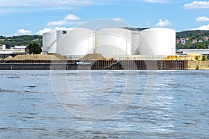 Storage silos, fuel depot of petroleum and gasoline on the banks of the river in western Germany on a beautiful blue sky with clou