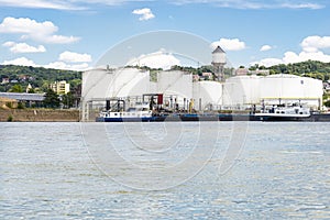 Storage silos, fuel depot of petroleum and gasoline on the banks of the river in western Germany on a beautiful blue sky with clou