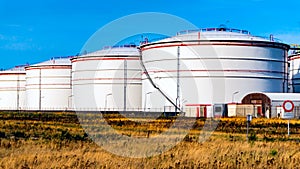 White tanks in tank farm with blue sky