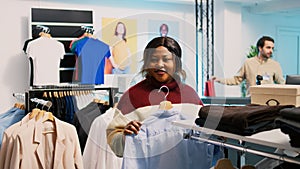 Store customer taking shirt off of hangers to buy clothes