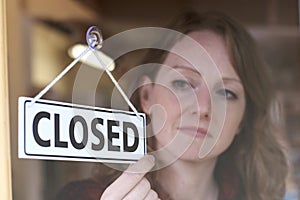 Store Owner Turning Closed Sign In Shop Doorway