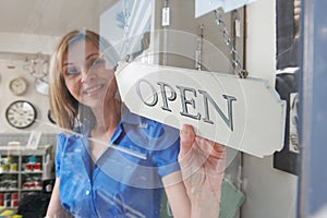 Store Owner Turning Open Sign In Shop Doorway