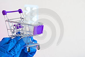 store trolley, Pills. hands in gloves hold a shopping cart with medicines. medical goods