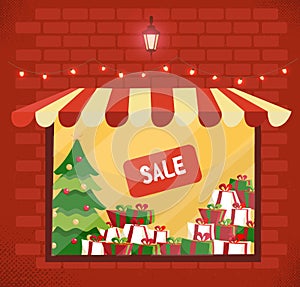 Storefront with Christmas gifts sale. Store and storefront window facade. Lighting shop window with sunblind in brick wall. Stacks