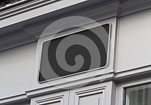 Storefront on a grey shop frontage Mockup. Empty store brand signboard frame in street