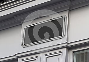 Storefront on a grey shop frontage Mockup. Empty store brand signboard frame in street photo