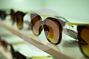 Storefront shelves of various modern sunglasses in retail store. Display rack full of sunglasses. Stand with sunglasses