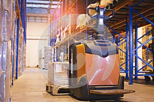 Storehouse area, Shipment. Electric forklift pallet jack unloading pallet goods in warehouse storage.