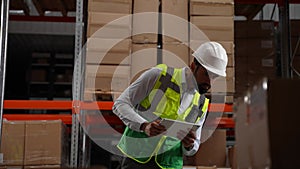 Storehouse employee with tablet taking inventory