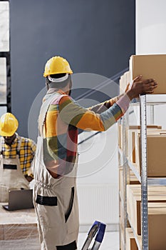 Storehouse employee taking box for order packing from shelf