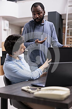 Storehouse workers analyzing metallic box order checking shipment logistics on laptop computer