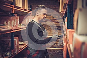 Storekeeper with handheld barcode scanner working in a warehouse