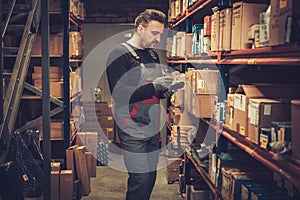Storekeeper with handheld barcode scanner working in a warehouse photo