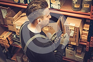 Storekeeper with handheld barcode scanner working in a warehouse photo