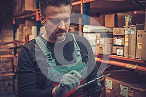 Storekeeper with manual pick list on a warehouse photo