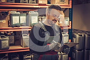 Storekeeper with manual pick list on a warehouse photo