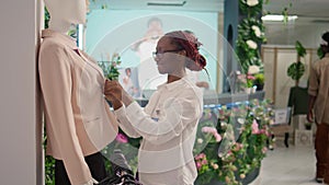 Storekeeper tidying up mannequin blazer