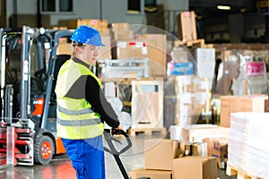 Storeman with mover at warehouse of forwarding