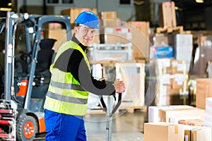 Storeman with mover at warehouse of forwarding