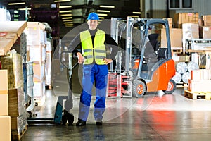 Storeman with mover at warehouse of forwarding