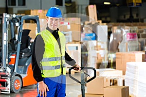 Storeman with mover at warehouse of forwarding