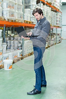 storeman using laptop in warehouse
