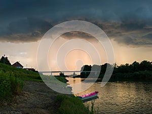 Storm arcus shaft and cumulonimbus cloud with heavy rain or summer shower, severe weather and sun glow behind rain. Landscape with