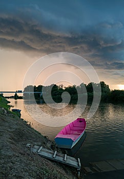 Storm arcus shaft and cumulonimbus cloud with heavy rain or summer shower, severe weather and sun glow behind rain. Landscape with