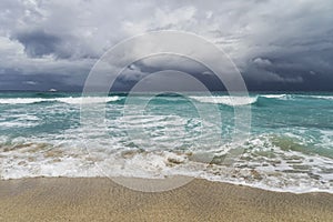 Storm in the Atlantic Ocean, waves, beach, coastline, white yacht on the horizon, low cloudiness