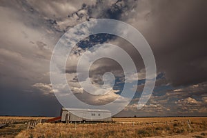 Storm brewing above shearing shed in a dry paddock in Central Victoria, Australia