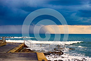 Storm cloud with rain over stormy sea.