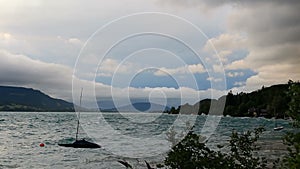 Storm cloud, sky over attersee lake with big waves and sailboat. Austria Alp mountain landscape