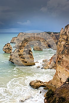 Storm clouds gather around the cliffs at a beach