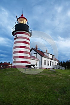 Storm Clouds Gather Around Red and White Striped Lighthouse in New England