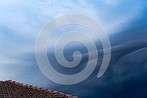 The storm is coming. Storm clouds above the roof. Heavy torrential rain. Rainfall flash flooding . Metorology weather forecast. photo