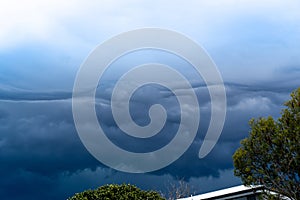 The storm is coming. storm clouds above trees and roofs. Heavy torrential rain. Rainfall flash flooding . Metorology weather photo
