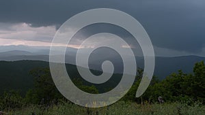 Storm is coming - dramatic rain clouds approach the hill